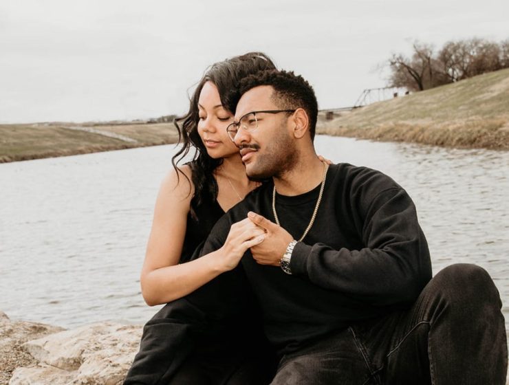 black couple in healthy relationship holding hands by a river