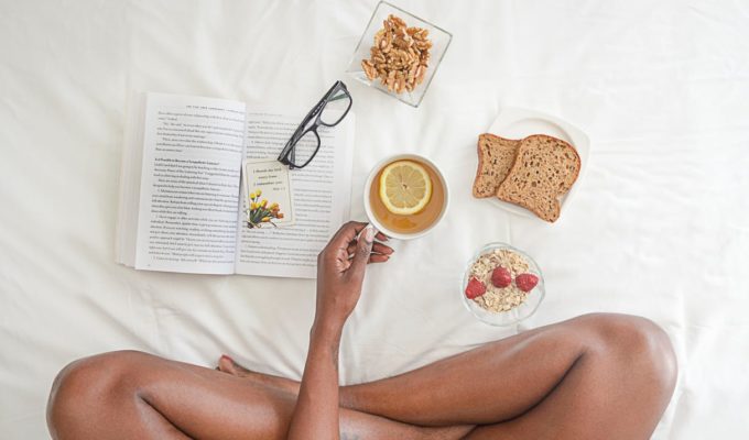 a-woman-eating-breakfast-and-reading