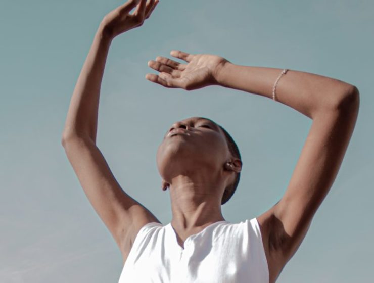 body odor image featuring woman dressed in white with arms raised