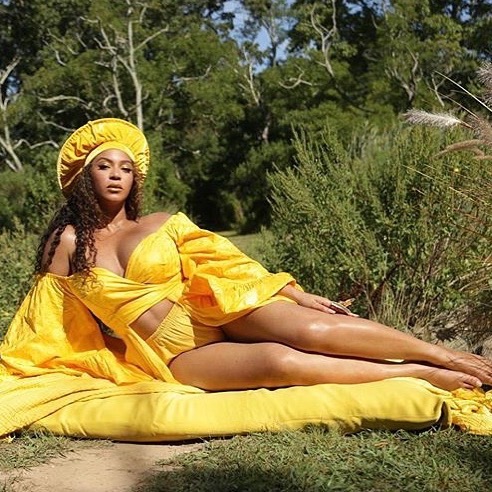 beyonce wears yellow dress and lies on grass