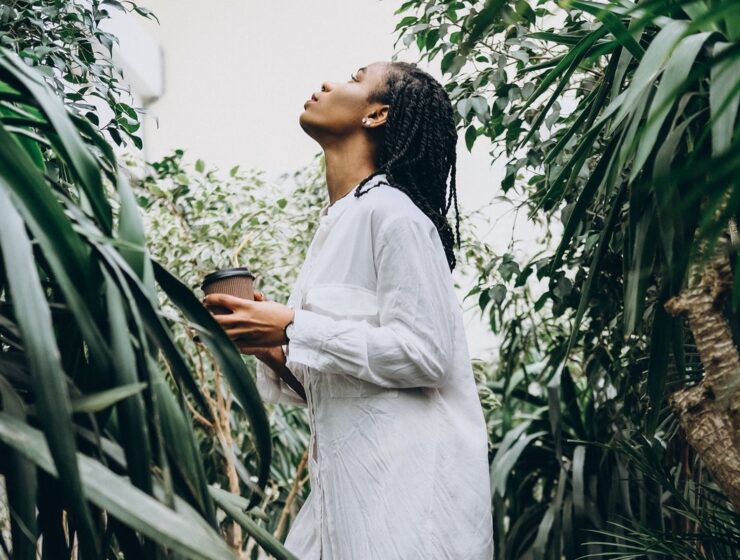 Spiritual Black woman looking up while surrounded by plants