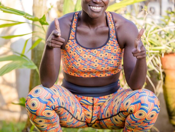 Black woman squatting and smiling in sports wear