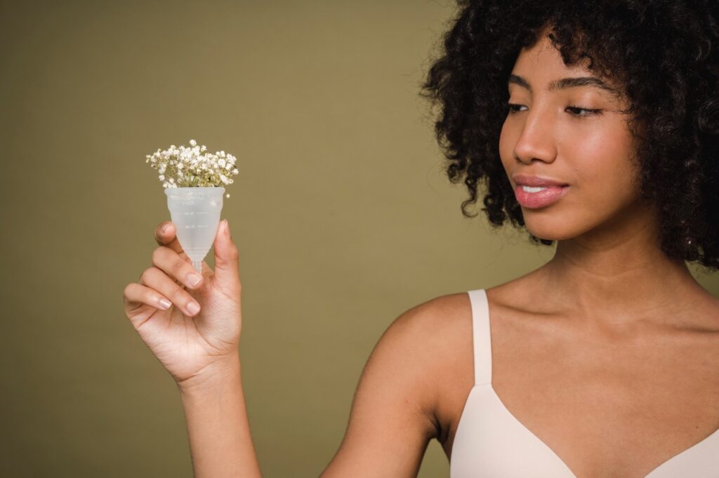 menstrual cramps - A black woman holding a menstrual cup
