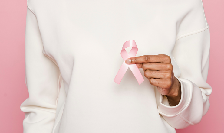 woman holding a pink cancer ribbon for cervical cancer