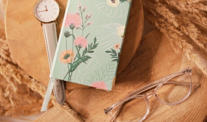 A journal, glasses, watch on a surface for intentions