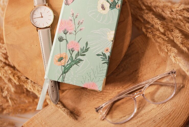 A journal, glasses, watch on a surface for intentions