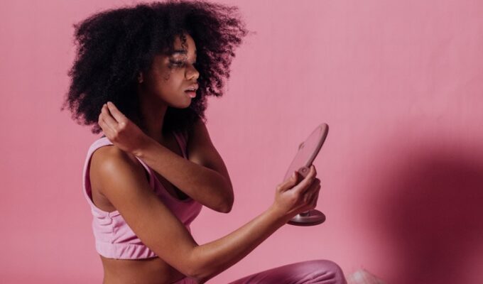 Black woman doing mirror work looking in the mirror