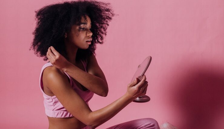 Black woman doing mirror work looking in the mirror