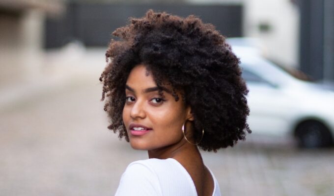 A Black woman with afro on hair care