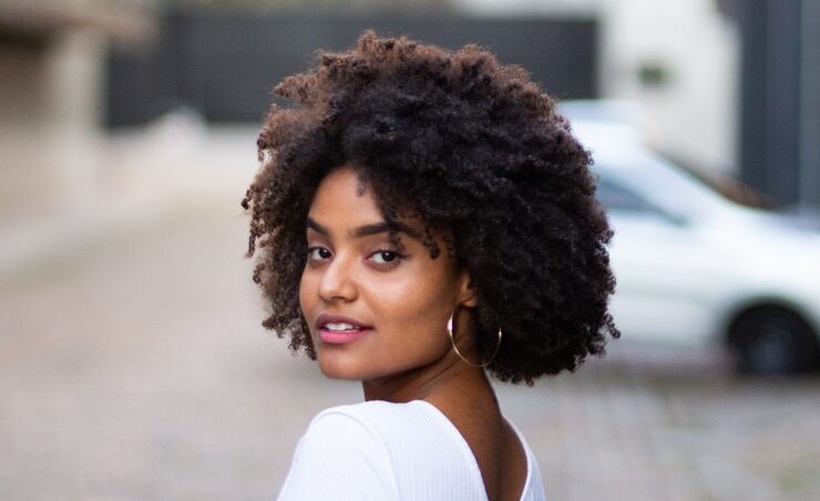 A Black woman with afro on hair care