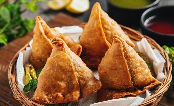 four tasty samosas displayed in a basket