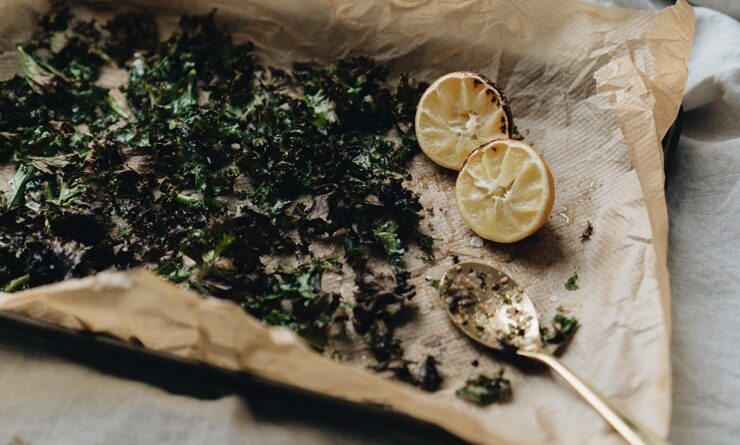 herbs, lime and spoon displayed on brown paper