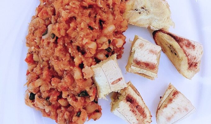 beans stew and roasted plantains on a white plate