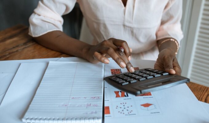 Black woman pressing a calculator addressing financial literacy