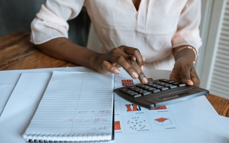 Black woman pressing a calculator addressing financial literacy