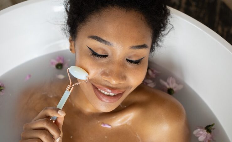 Black woman using a jade roller to massage her face
