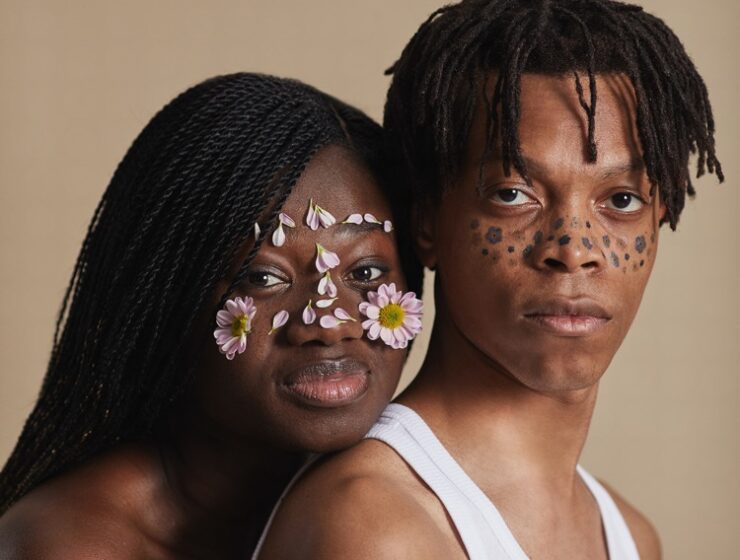 Cultural influences in relationship displayed by a black couple with marks and flowers on their faces.