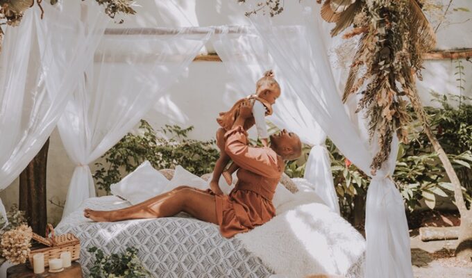 A black woman holding up a child celebrating motherhood