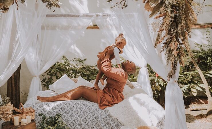 A black woman holding up a child celebrating motherhood
