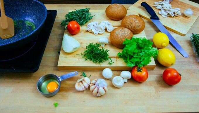 Potato salad ingredients, including lemon, garlic, onions, displayed on a table