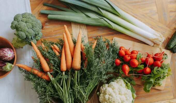 Vegetables to help reduce uterine fibroids displayed on a wooden table