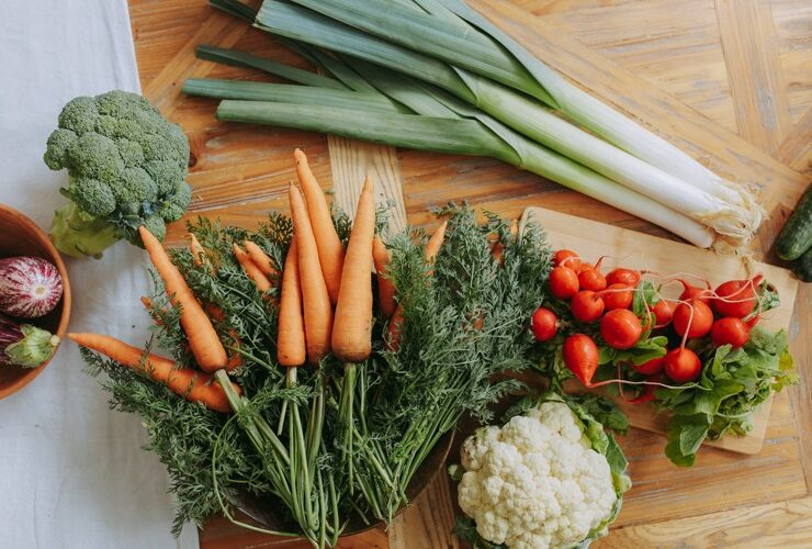 Vegetables to help reduce uterine fibroids displayed on a wooden table