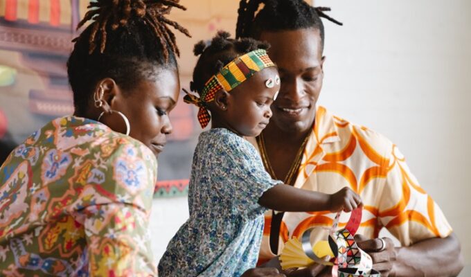 Creativity in children being displayed by black parents with a child