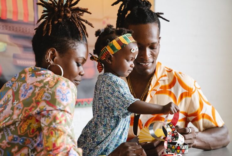 Creativity in children being displayed by black parents with a child