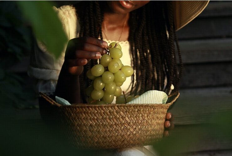 Black woman snacking with green grapes