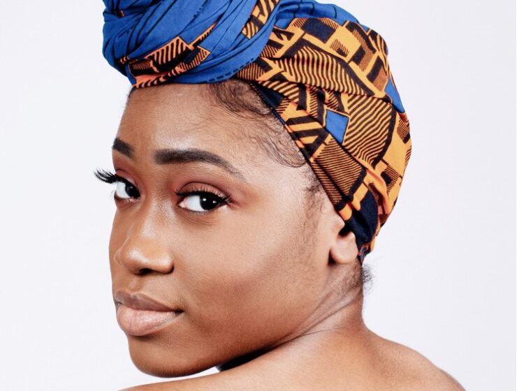 Black woman displaying natural beauty wearing a scarf and bare shoulders