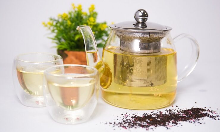 Herbal teas steeped in a glass jug and glass mugs