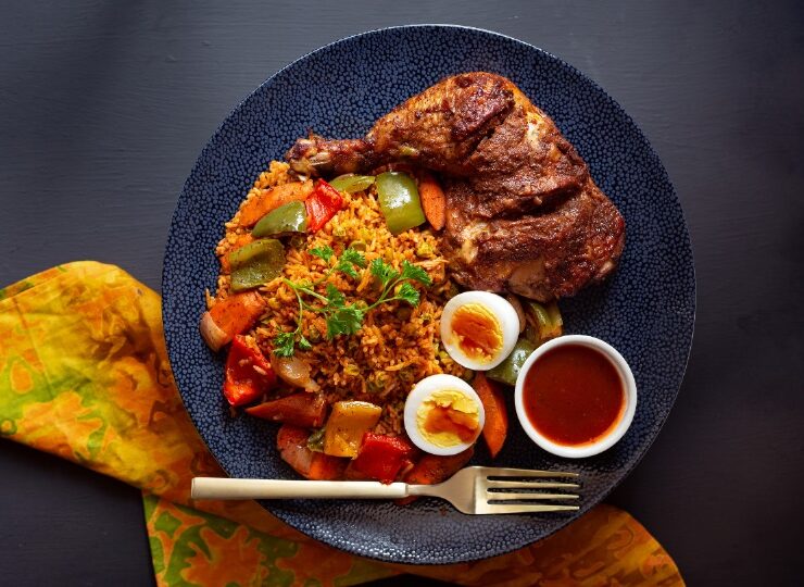 a place of jollof rice with chicken, vegetables and boiled egg.