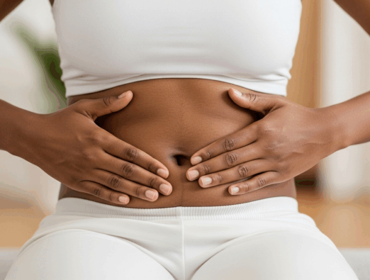 A black woman touching her stomach to signal womb cleansing