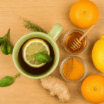 Herbal tea with lemon, honey, turmeric, and ginger on a wooden table representing natural remedies for common cold.