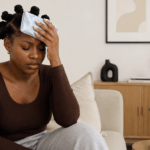African woman using a cold compress, which is one of the natural remedies for headaches.