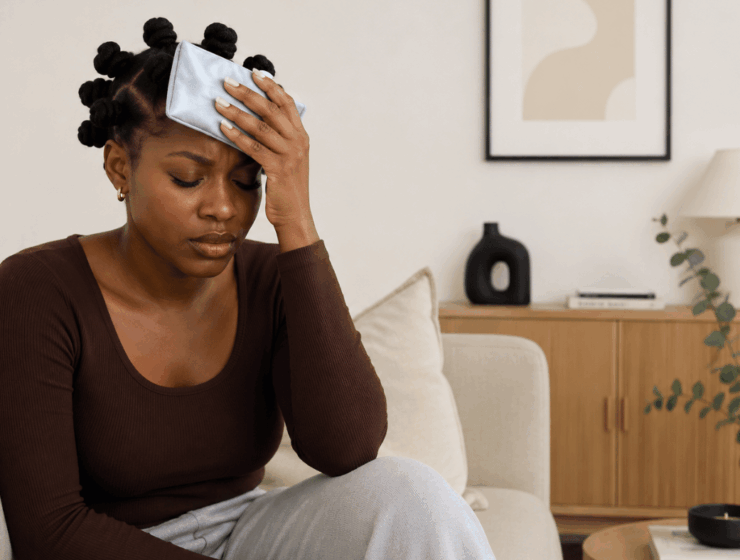 African woman using a cold compress, which is one of the natural remedies for headaches.