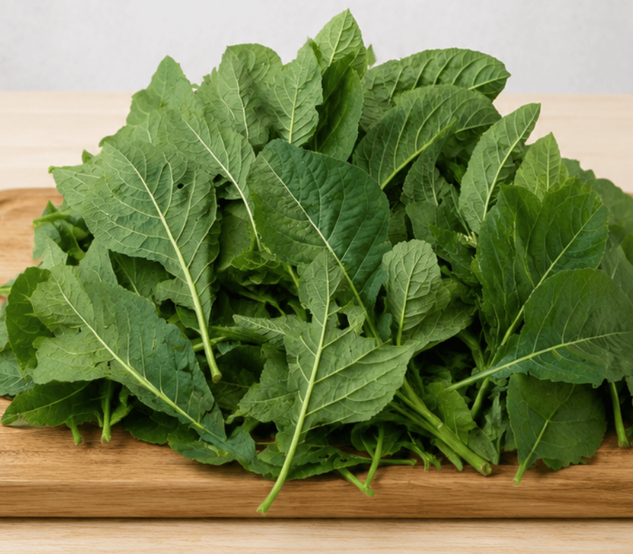 Fresh bitter leaf (Vernonia amygdalina) piled on a wooden chopping board